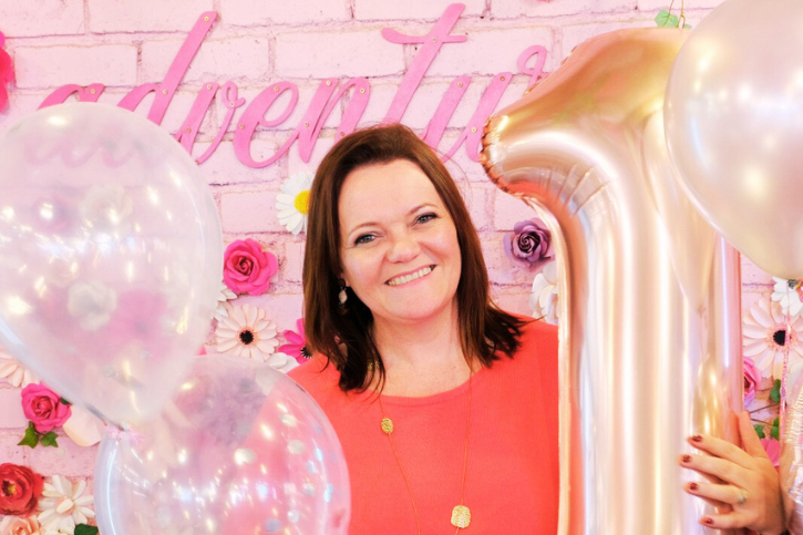 A lady standing between balloons