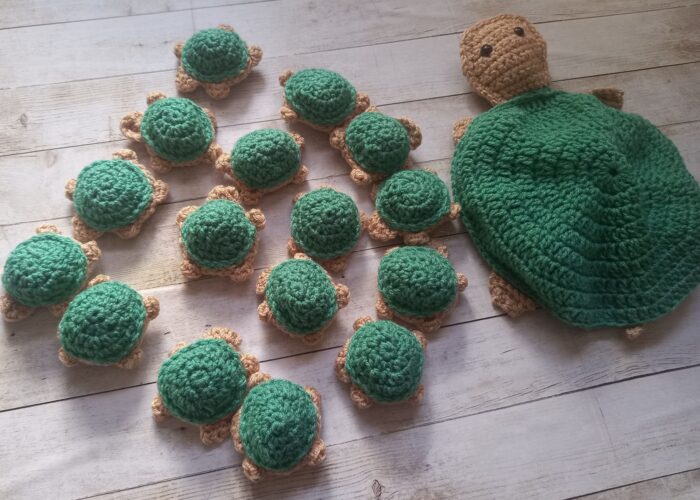 Green turtle Momma with sixteen little baby turtles. The babies have matching coloured tummies and form part of a Turtle Memory Game for Children